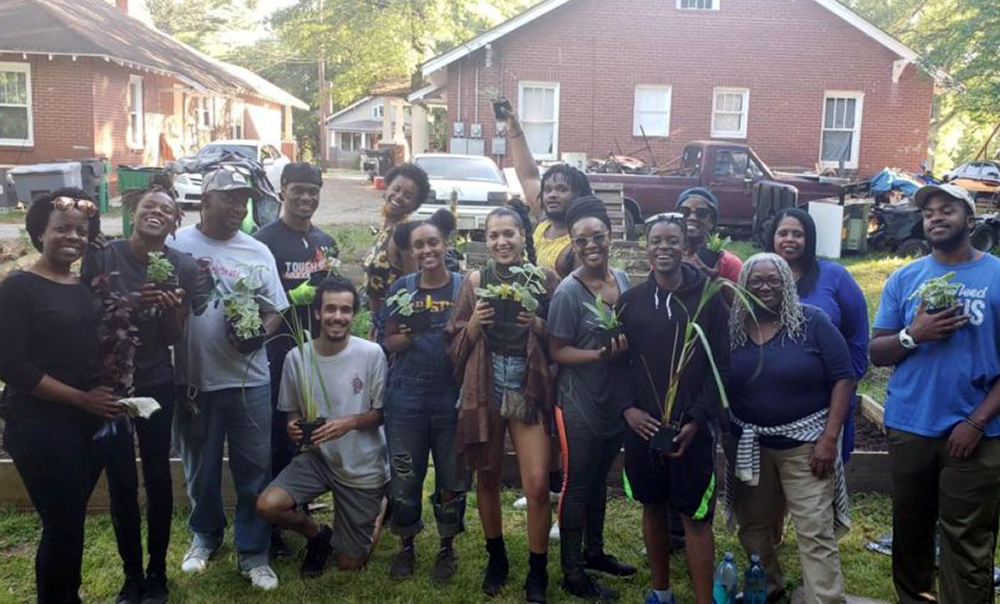 Brandon Ruiz (shown kneeling in front) and the Charlotte Herbal Accessibility Project planting out the Afro-Caribbean garden on the west side of town.