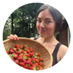 Sarah Nicole Snyder is holding a woven basket full of freshly picked strawberries.